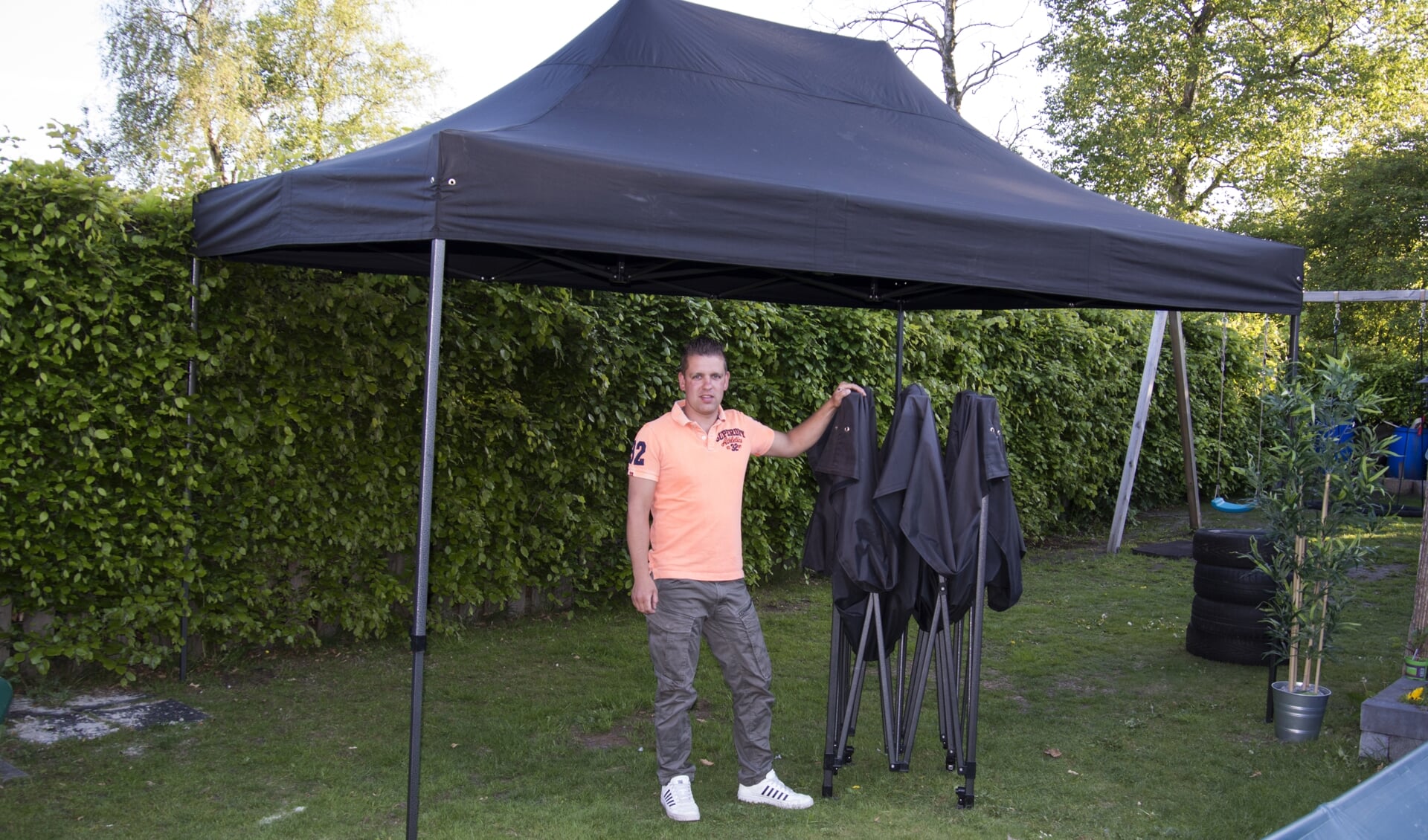 Bjorn Staal poseert bij een kleinere versie van de ontvreemde partytent. Foto: Marion Verhaaf
