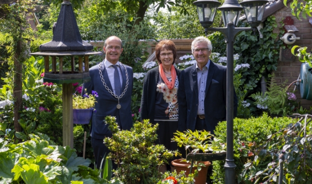 Het bruidspaar met burgemeester Van Hedel in hun prachtige tuin. Foto: Marion Verhaaf