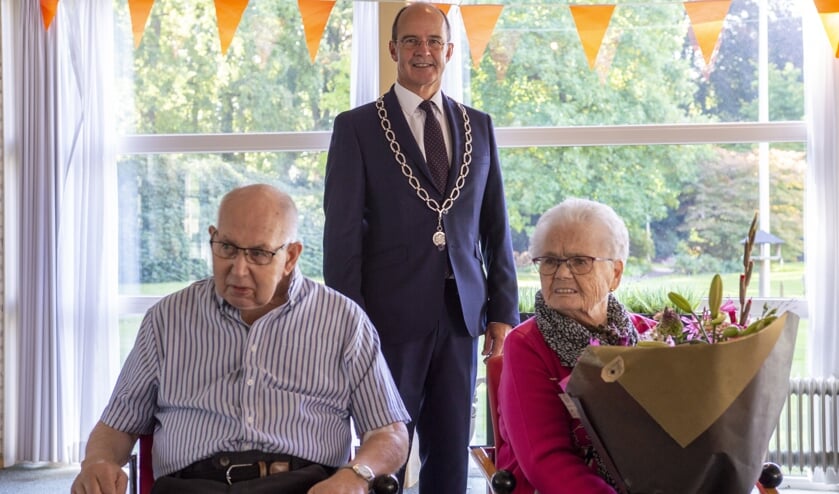Hendrik (84jr) en Dinie (85jr) Draaijer-Schotpoort met burgemeester Van Hedel op gepaste afstand. Foto: Marion Verhaaf
