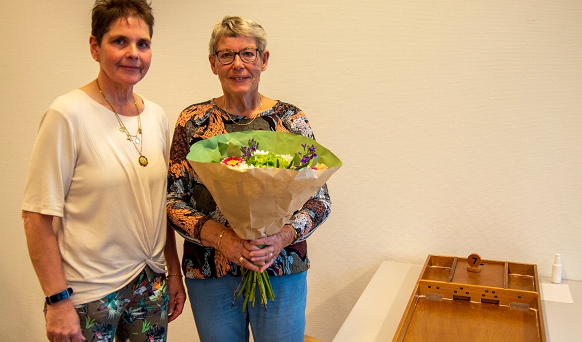 Voorzitter Ineke Draaijer geeft Jannie Tempelman (80jr) en Fenna Verbeek (92jr) een bos bloemen. Foto: Marion Verhaaf
