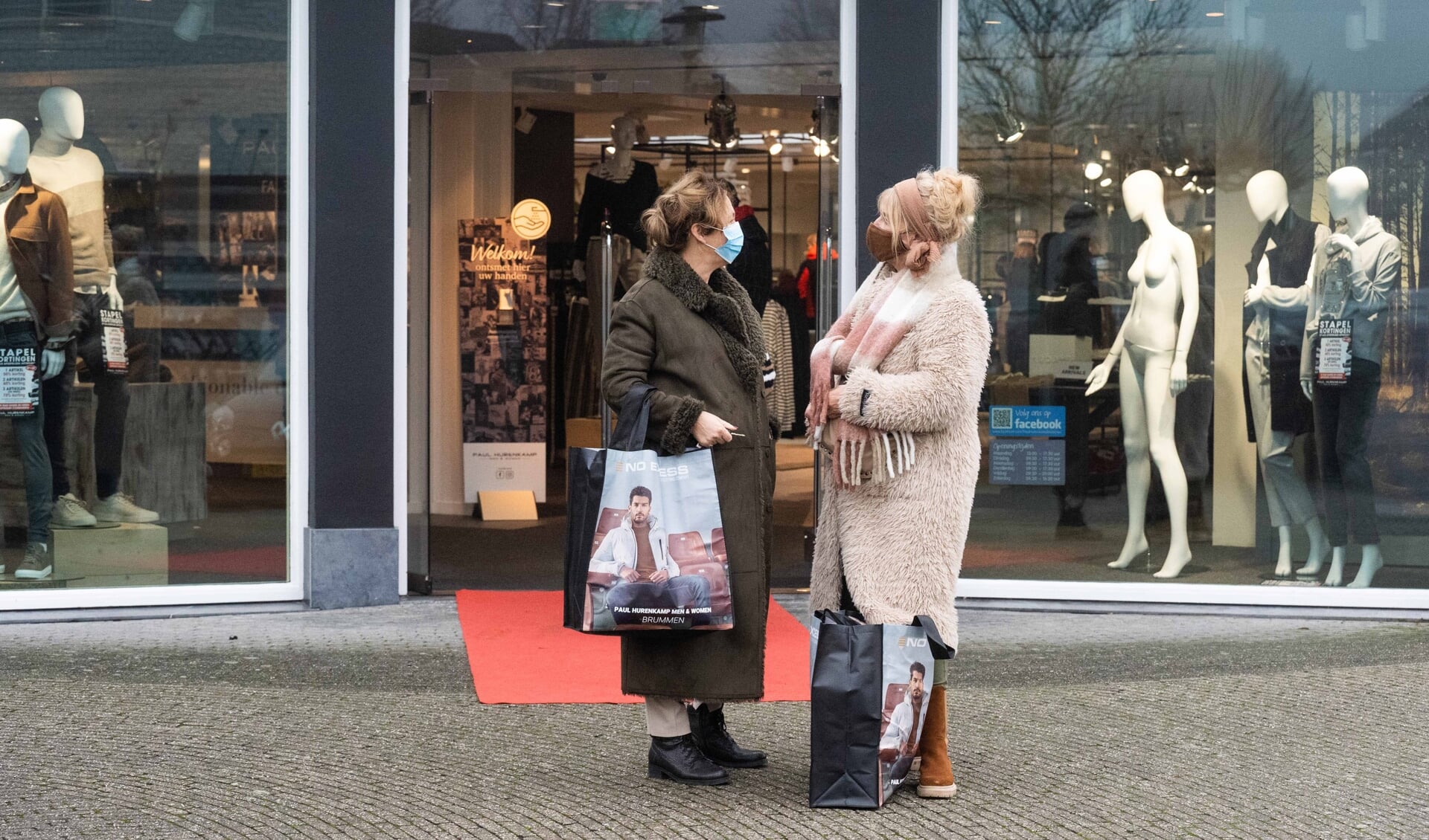 Twee winkelende dames met verse aankopen voor modezaak Paul Hurenkamp.