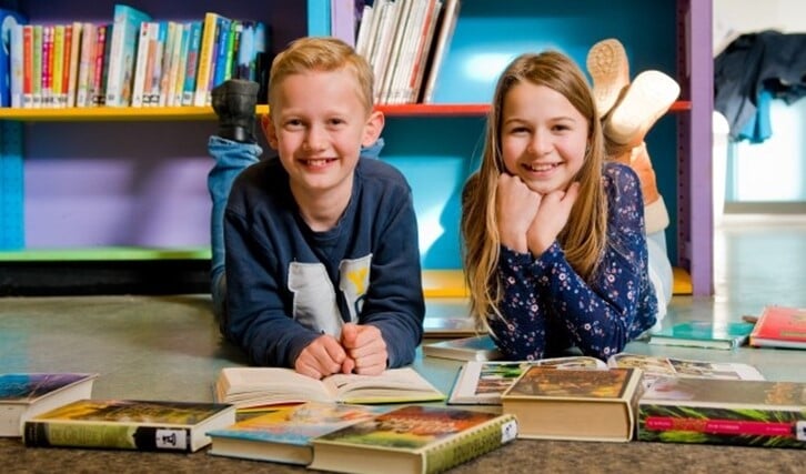 Spiros en Sophie, twee van de BiebExperts van basisschool De Sterrendans, hopen dat alle kinderen op school lezen net zo leuk gaan vinden als zij. (Foto: Maaike van Helmond)