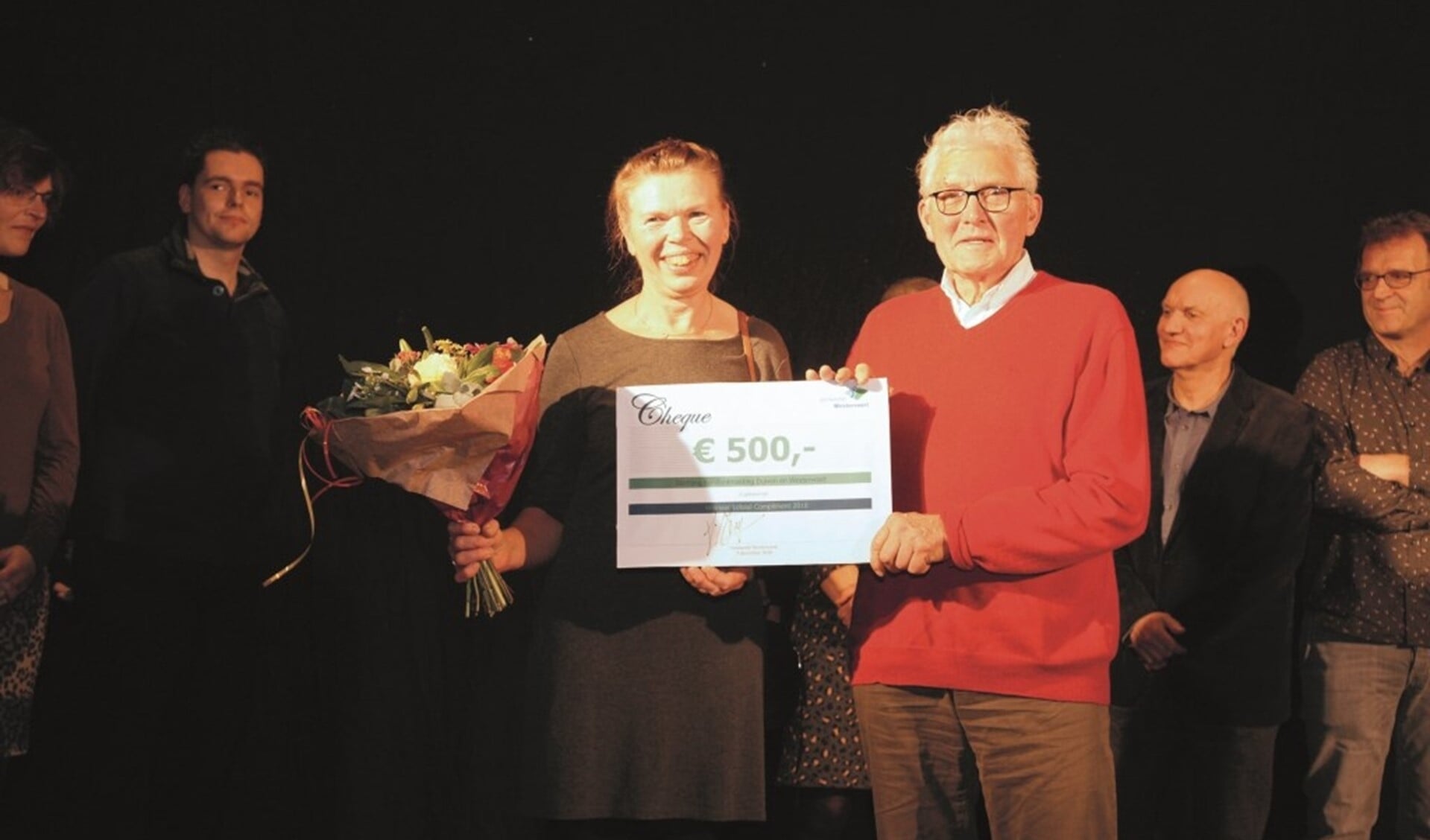 De bestuursleden Piet van Schaik en Hillie van Mourik van de Stichting Kerstontmoeting Duiven en Westervoort met de cheque van 500 euro.