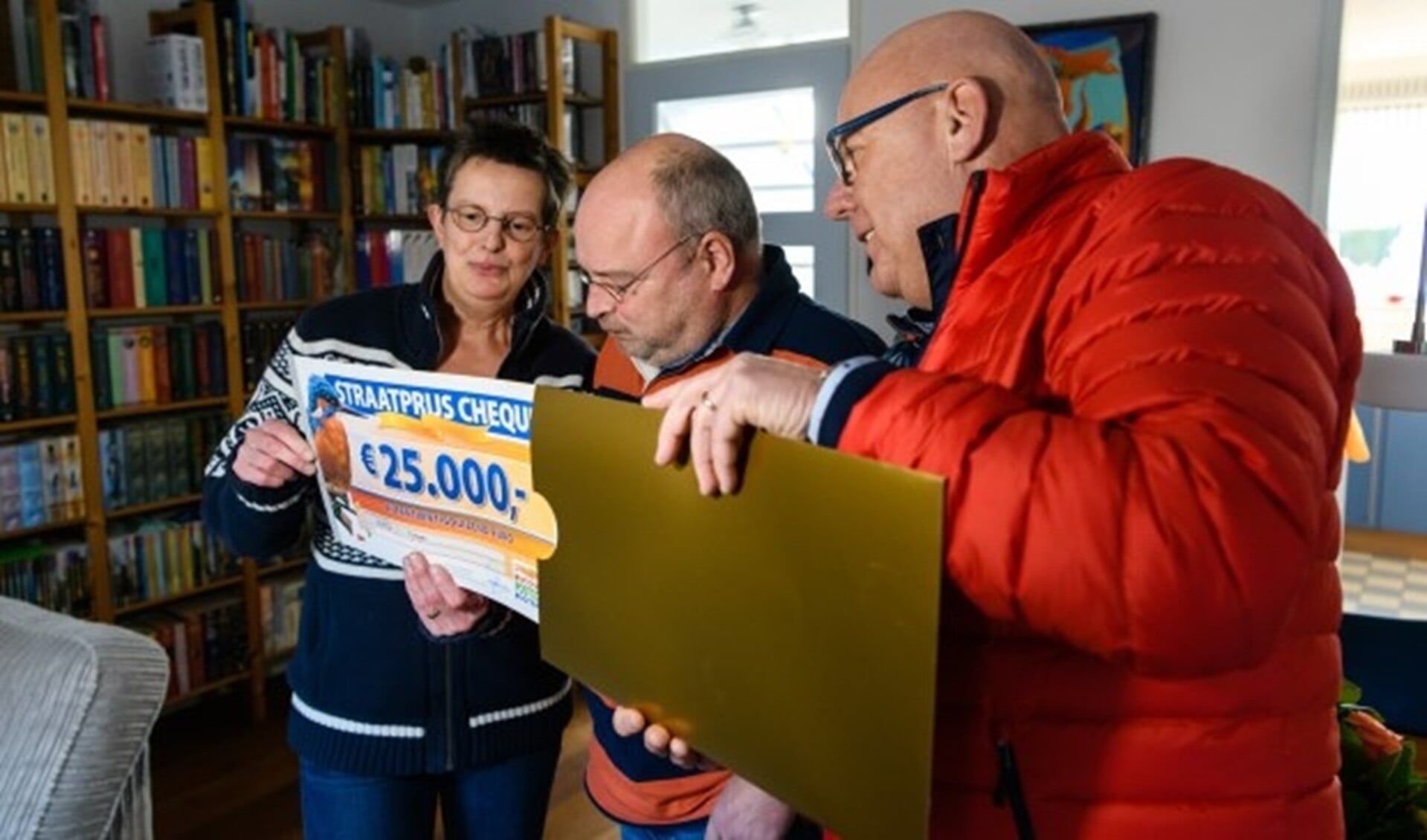 Helma en André uit Nijmegen winnen 25.000 euro en worden verrast door Postcode Loterij-ambassadeur Gaston Starreveld met de PostcodeStraatprijs-cheque. (Roy Beusker Fotografie)