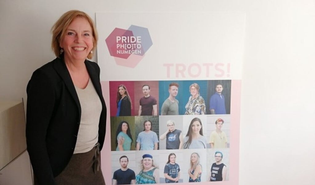 Geke Hartman bij een poster met daarop trotse transgender personen. (Foto Hidde Pel)  