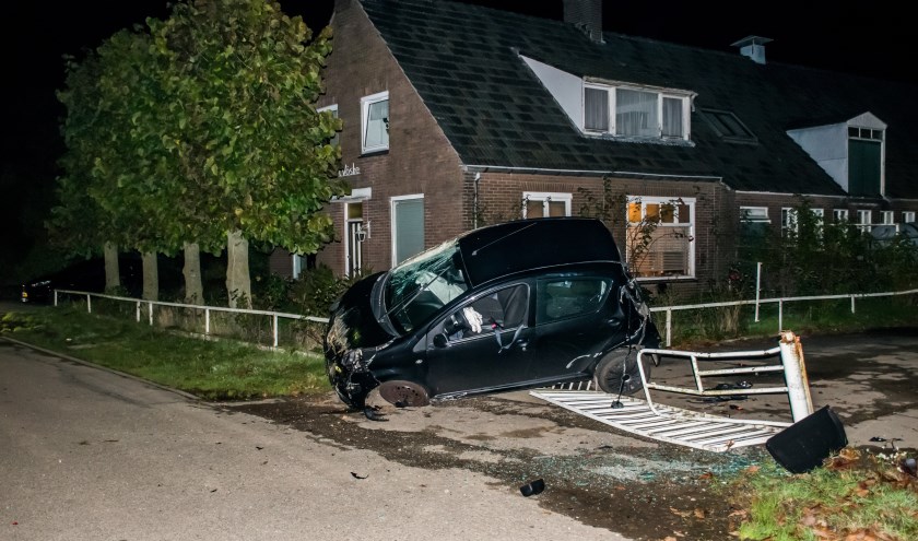 Auto op zijn kant tegen hekwerk. (foto: Waldie Rutten)