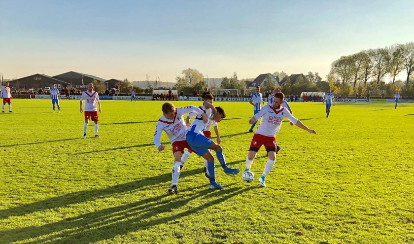 Arnhemse Boys (blauwe broek) in de greep van en bij RKSV Driel. Laatstgenoemde won de derby en kelderkraker van 3D West met liefst 6-1.