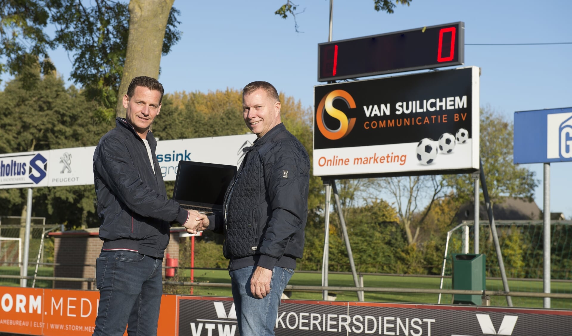 Cor van Suilichem en Dirko Hendriksen voor het nieuwe scorebord van VV Dodewaard.(foto: Thomas van Beek)