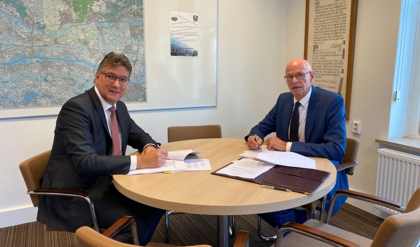 Wethouder Hans Keuken en TCO-voorzitter Kees van Rooijen tijdens ondertekenen overeenkomsten Laanboomhuis. (foto: Gemeente Neder-Betuwe)