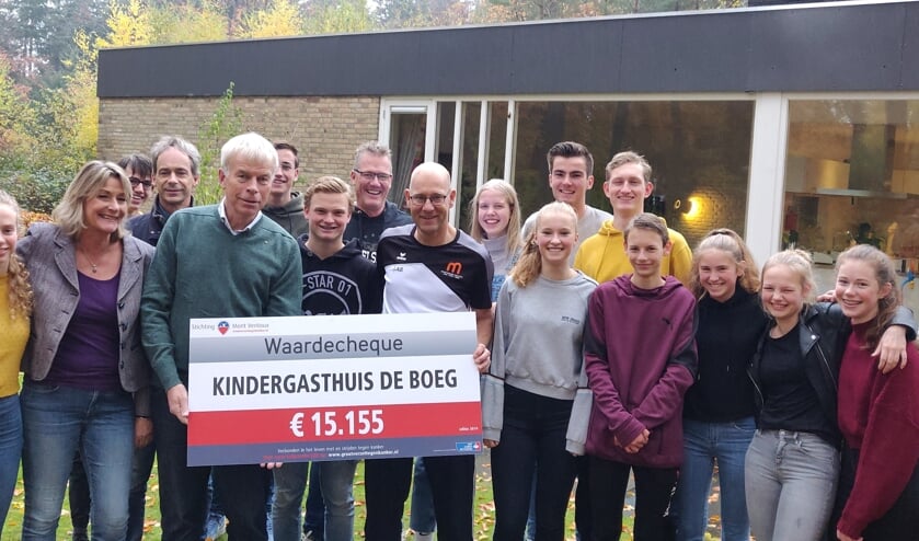 Leerlingen van het Montessori College bij de overhandiging van de cheque aan voorzitter Sjaak Thijssen van De Boeg; rechts Wilbert Lamers docent lichamelijke opvoeding aan het Montessori College