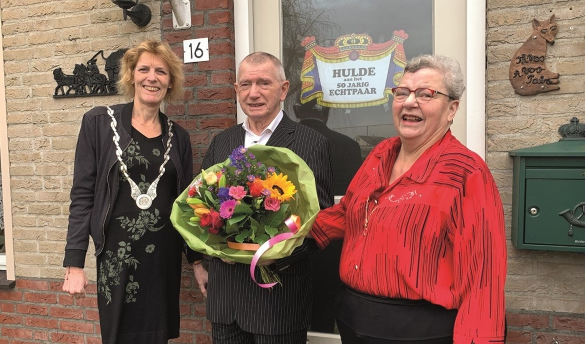 Loco-burgemeester Ineke Knuiman feliciteert Theo en Agnes Vos, terwijl de speciaal voor deze gelegenheid opgetrommelde Henk Nijland tot grote hilariteit van Agnes de foto maakt.