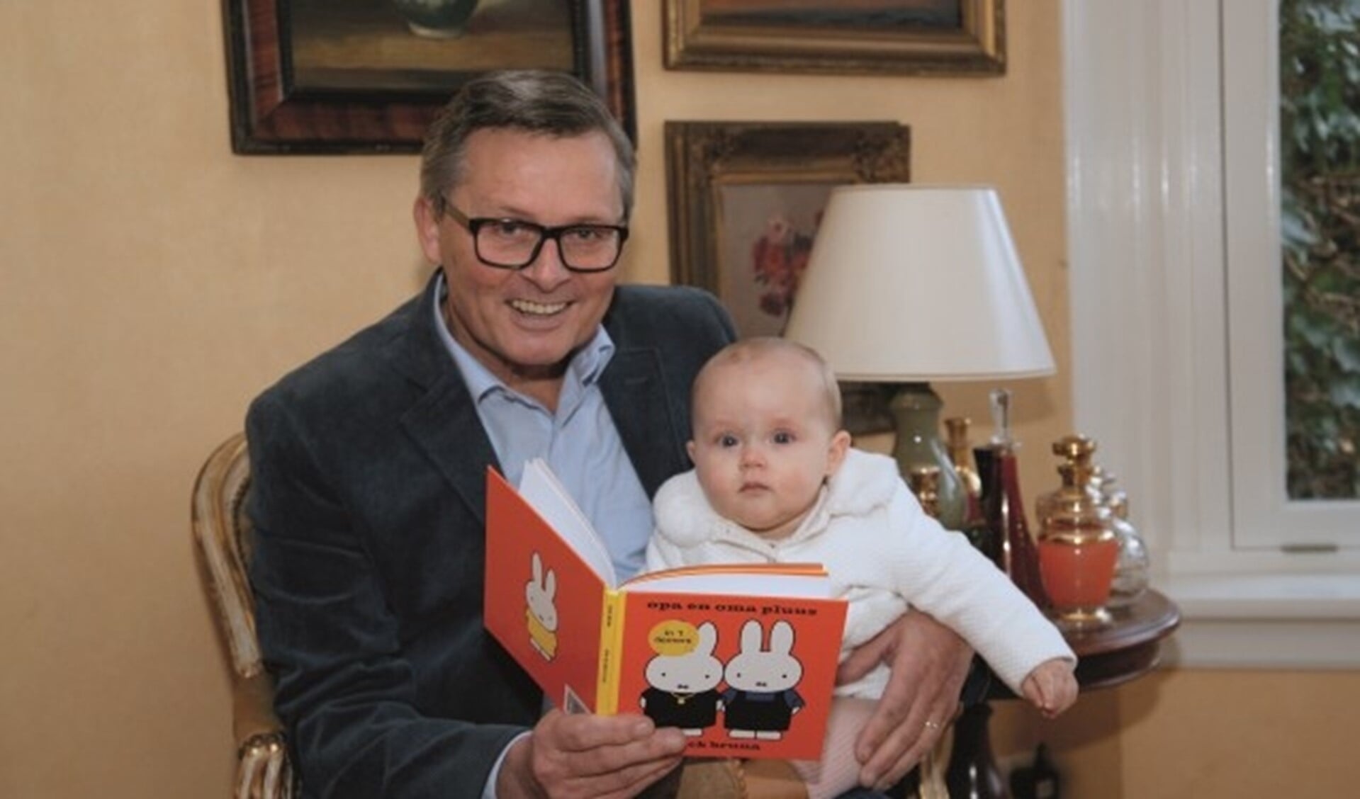 Kees Krechting leest zijn kleindochter Norah May voor uit het Nijntje-boekje 'Opa en oma pluus'.