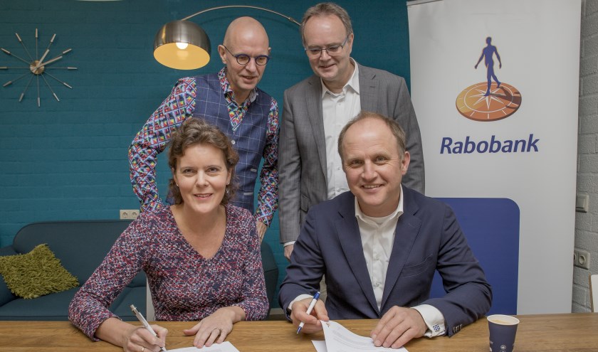 Onder het toeziend oog van economiedocent Ben Nijmeijer (links) en directielid Ben van den Anker van het Candea College in Duiven tekenen Esther van Kraaij (Rabobank Arnhem en Omstreken) en Niek den Tex (Scholenstrijd) de overeenkomst. (foto: Sjoerd Geurts)