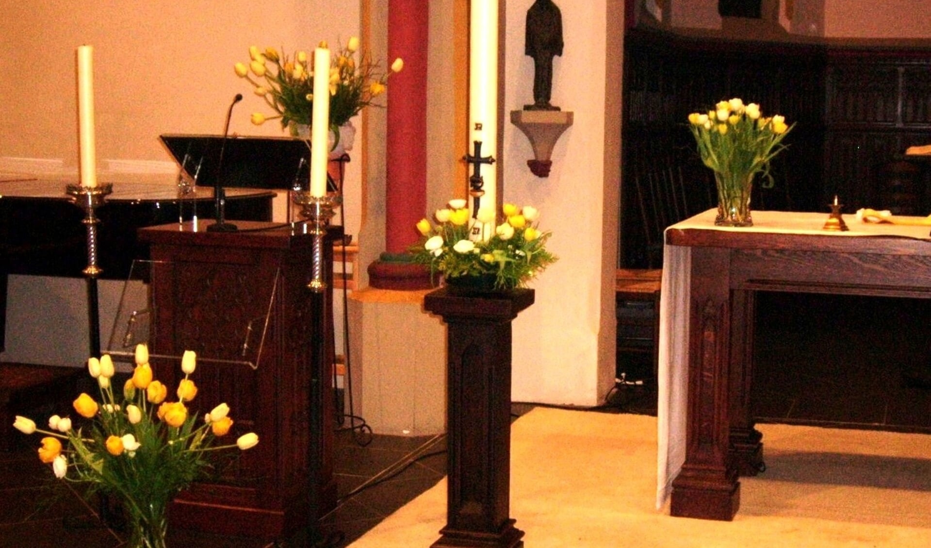 Paaskaars met andere kaarsen en bloemen in de kloosterkapel. (foto: Annetje Geertsen)