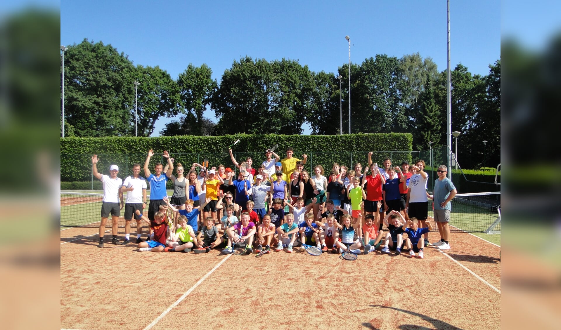 De hele groep van het Delftse tenniskamp poseert op de banen van TV Groesbeek. (foto: TV Groesbeek). 