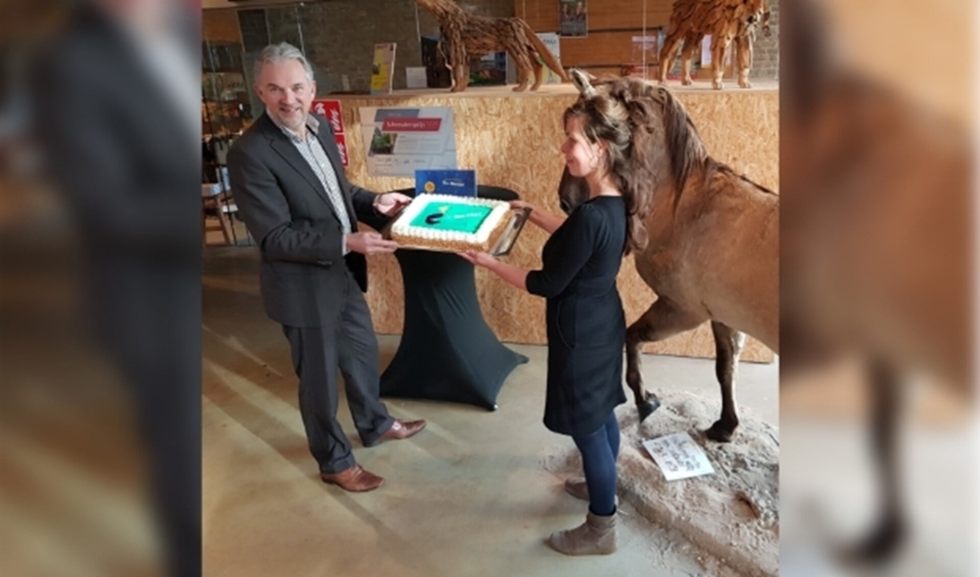 Hans Hooijmaijers, de nieuwe directeur van De Bastei, reikt een taart uit aan de baliemedewerkers, die een actieve rol hebben gespeeld in het werven van kinderen voor museuminspecties 