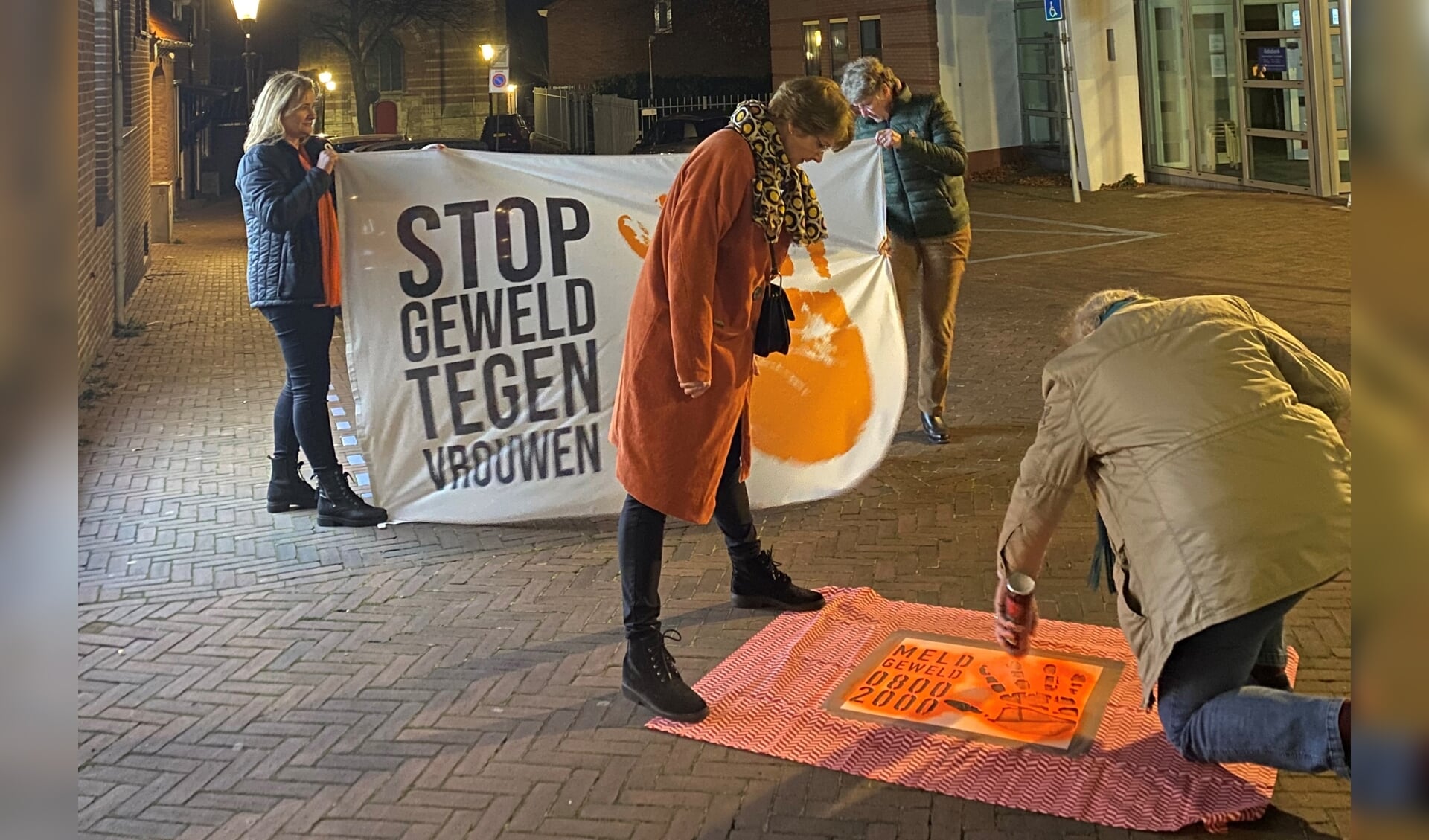 Wethouder Barth van Eeten spuit het erste logol Meld Geweld op straat als start van Orange the World in Rhenen.
