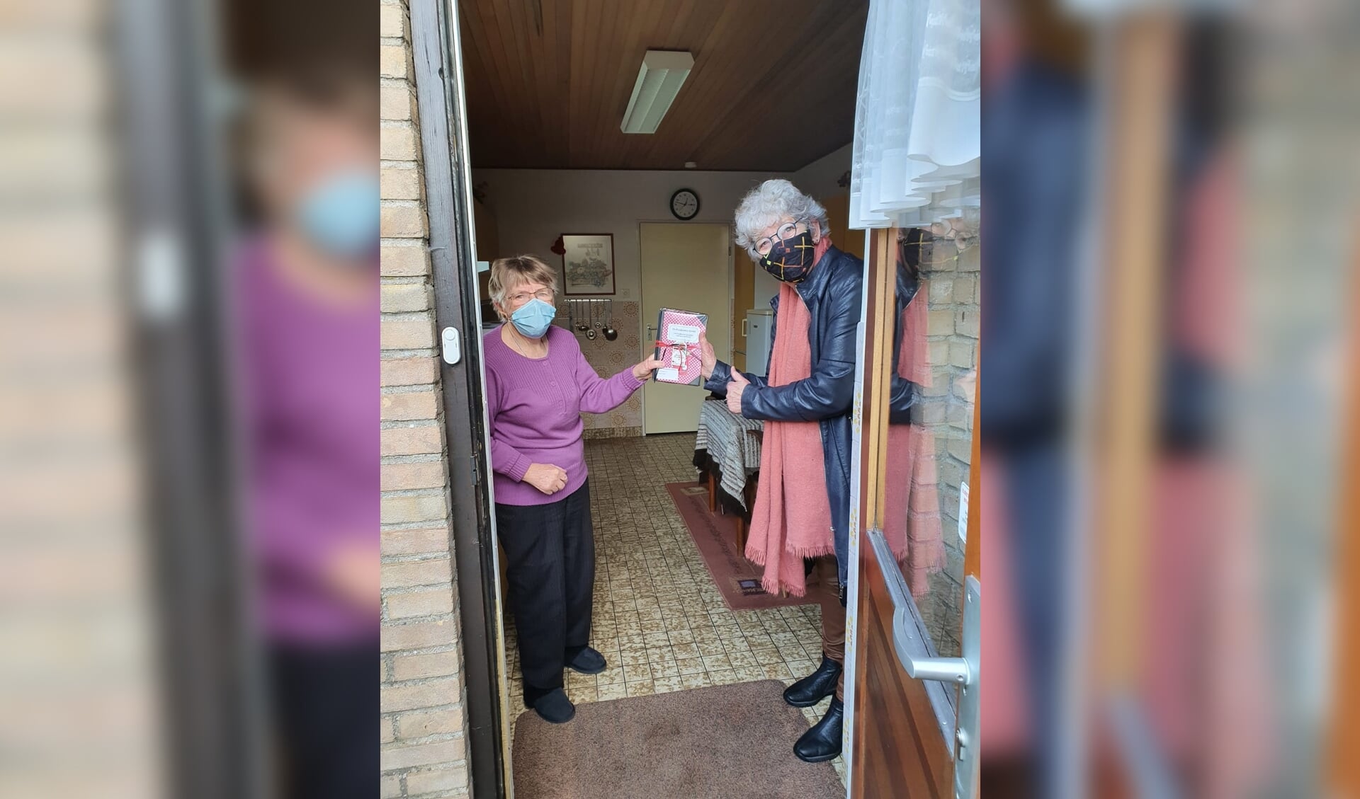 Marion Schouten, vrijwilligster Huiskamer van Elst overhandigt het kookboek aan een blije Ans Schoonderbeek. (foto: Ton Schouten)
