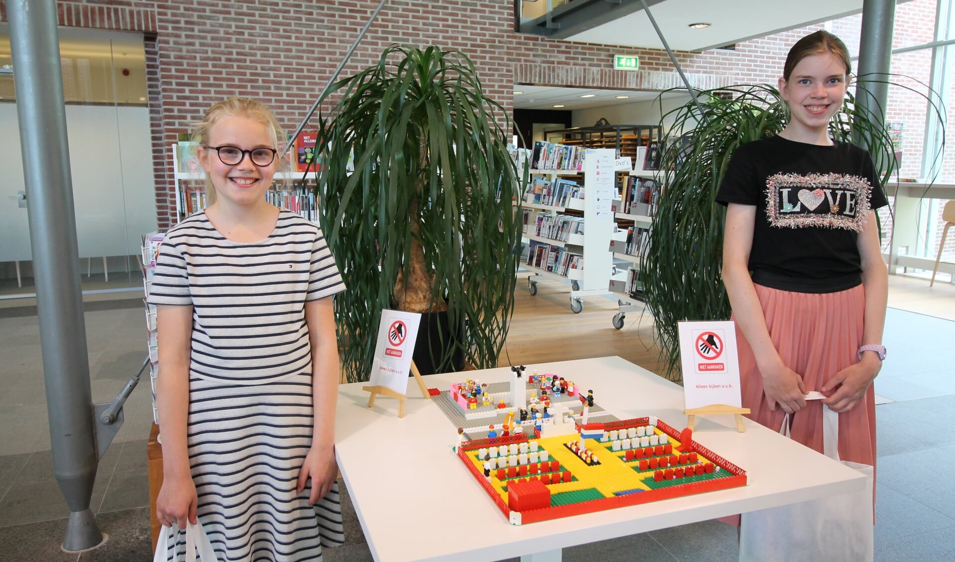 Emma en Johanna Hulsman bij hun Lego-creatie van de Grebbeberg. (foto: Marco Diepeveen)