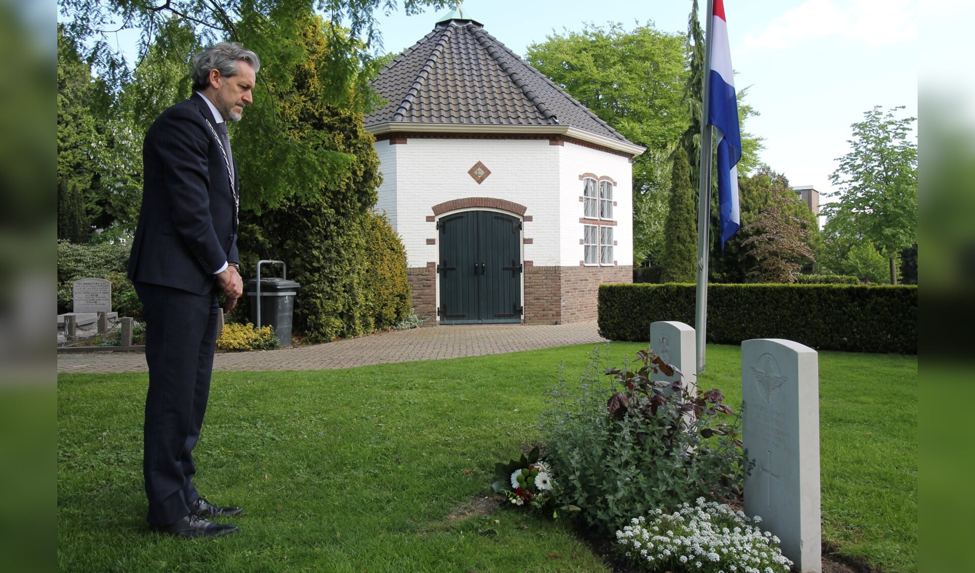 Burgemeester Hans van der Pas legt bloemen op de begraafplaats aan de Achterbergsestraatweg in Rhenen. (foto: Wim Hulsman)