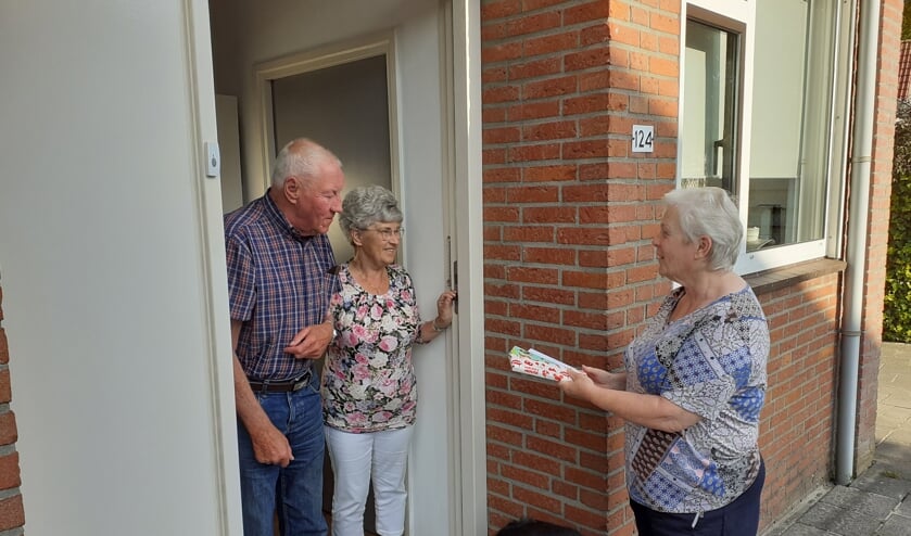 Een vrijwilligster bezorgt de kaart en chocolade aan de fam Schenk-Wolters. (foto: Jack op den Brouw)