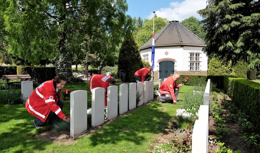 Foto’s van de vrijwilligers die bloemen leggen op de algemene begraafplaats aan de Achterbergsestraatweg in Rhenen.