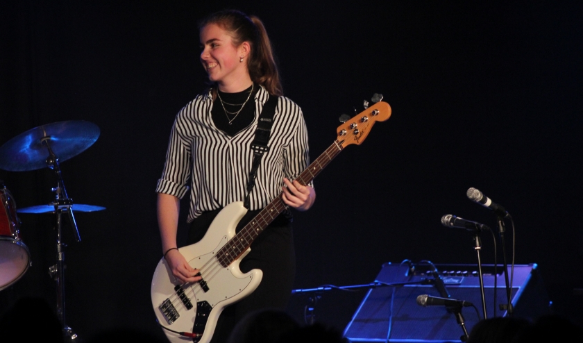 Linn spelend op haar basgitaar tijdens een optreden met haar band op een van de muziekavonden die de school regelmatig organiseert. (foto: Veerle Karsdorp)