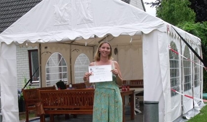 Moeder Maartje neemt het iconen-certificaat met prachtige resultaten in ontvangst namens een van de leerlingen. (foto: Toine Langerwerf)