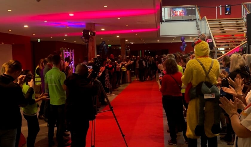 Beroepsbeoefenaren juichen de leerlingen toe die op de rode loper binnenkomen. (foto: Floor Thijsen)