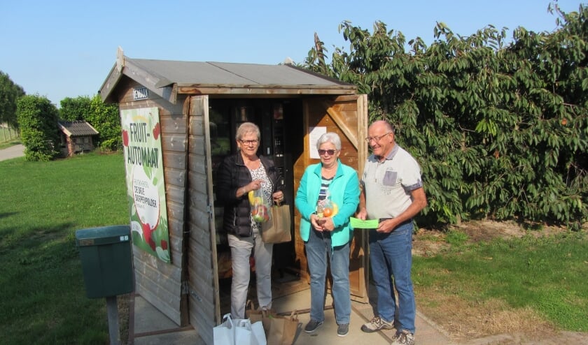 Bestuursleden met fruittassen voor de leden.