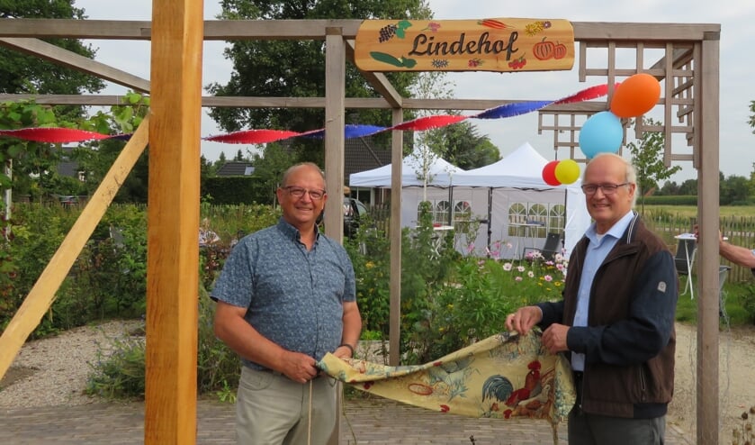 <p>Vrijwilligers Ton de Jong en Bart Kleijer onthullen de naam van de moestuin. (foto: G. Verboom)</p>