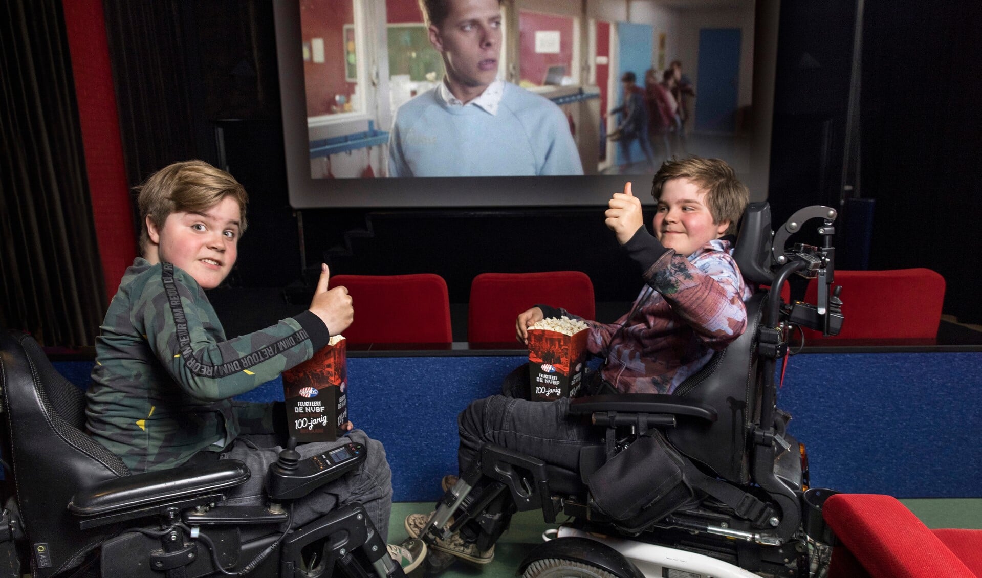 Milan en Ilya zitten met hun rolstoel op de beste rij in de Bio Bioscoop. 