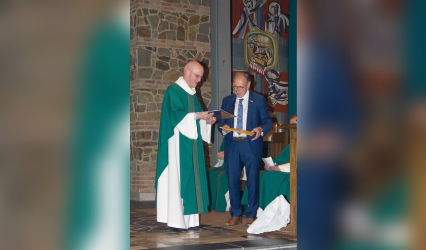 <p>Kapelaan Hans van der Donk ontvangt uit handen van Jacques Pouwels het Mariaboek van de kerklocatie Malden. </p>