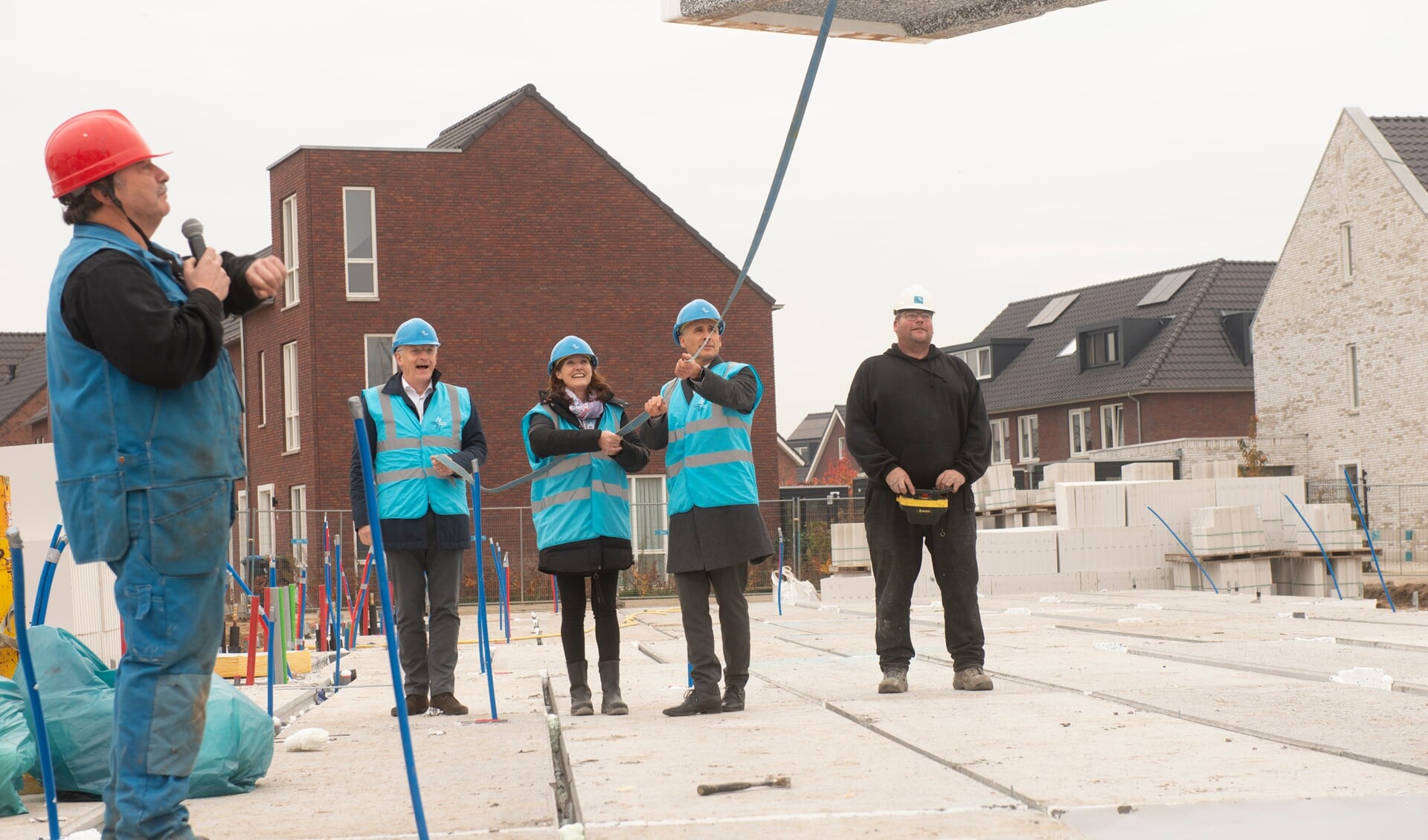 De vloerplaat wordt gelegd en tekent de bouwstart van fase III van Soetegaerde in het Nijmeegse stadsdeel Waalsprong. V.l.n.r. (met blauwe helm) André ten Vergert, Antoinette Wilmot en Kees van Aalsburg. 