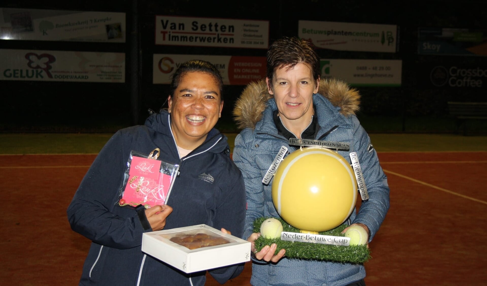 Twee van de trotse winnaars uit Dodewaard (Maresa Rutasouw (l) en Sylvia Elings) met de Neder-Betuwe Cup.