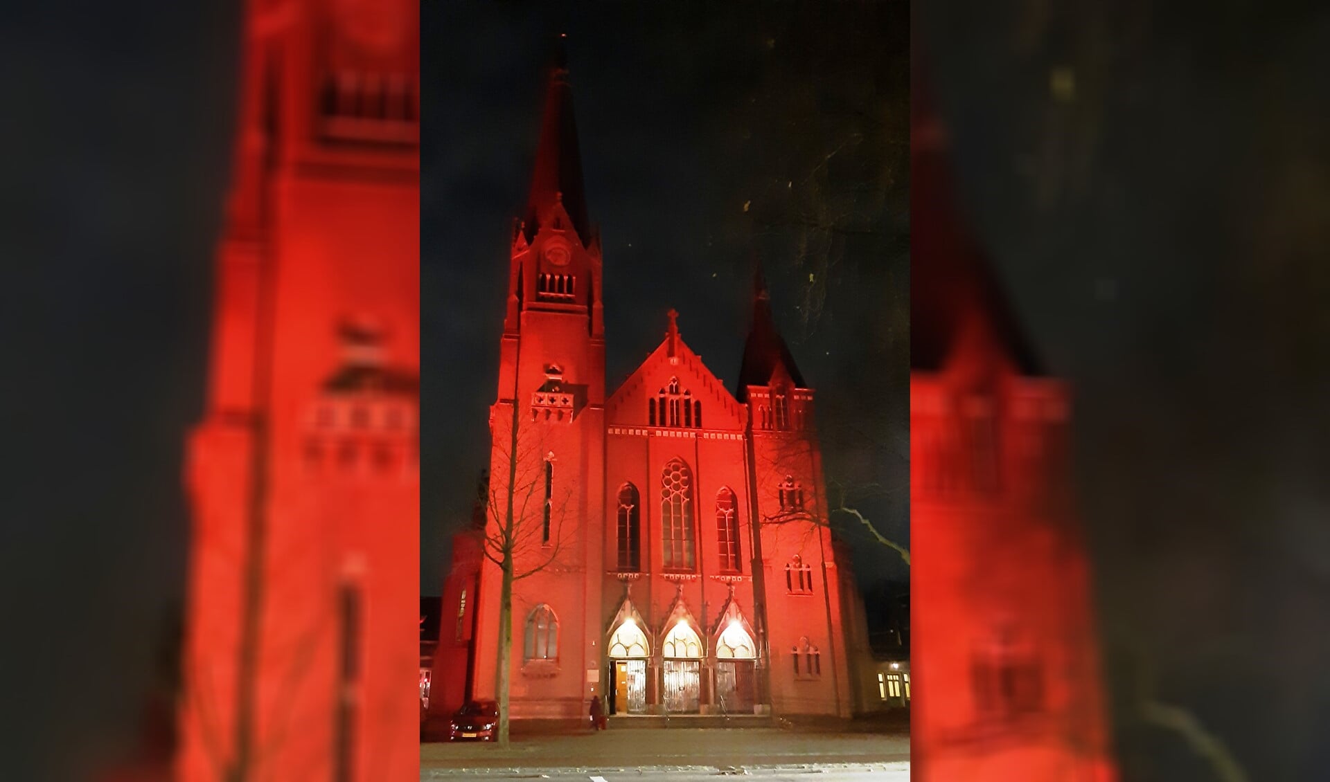 De kerk baadt in rood licht.