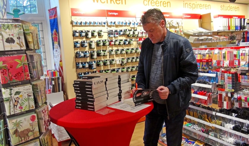 <p>Arno Arts signeert ruim vijftig boeken bij Bruna Groesbeek. (foto: Peter Hendriks)</p>