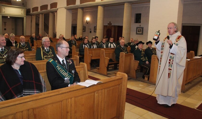 <p>Pastoor Aloys van Velthoven preekt met fles Jagermeister in zijn hand.</p>
