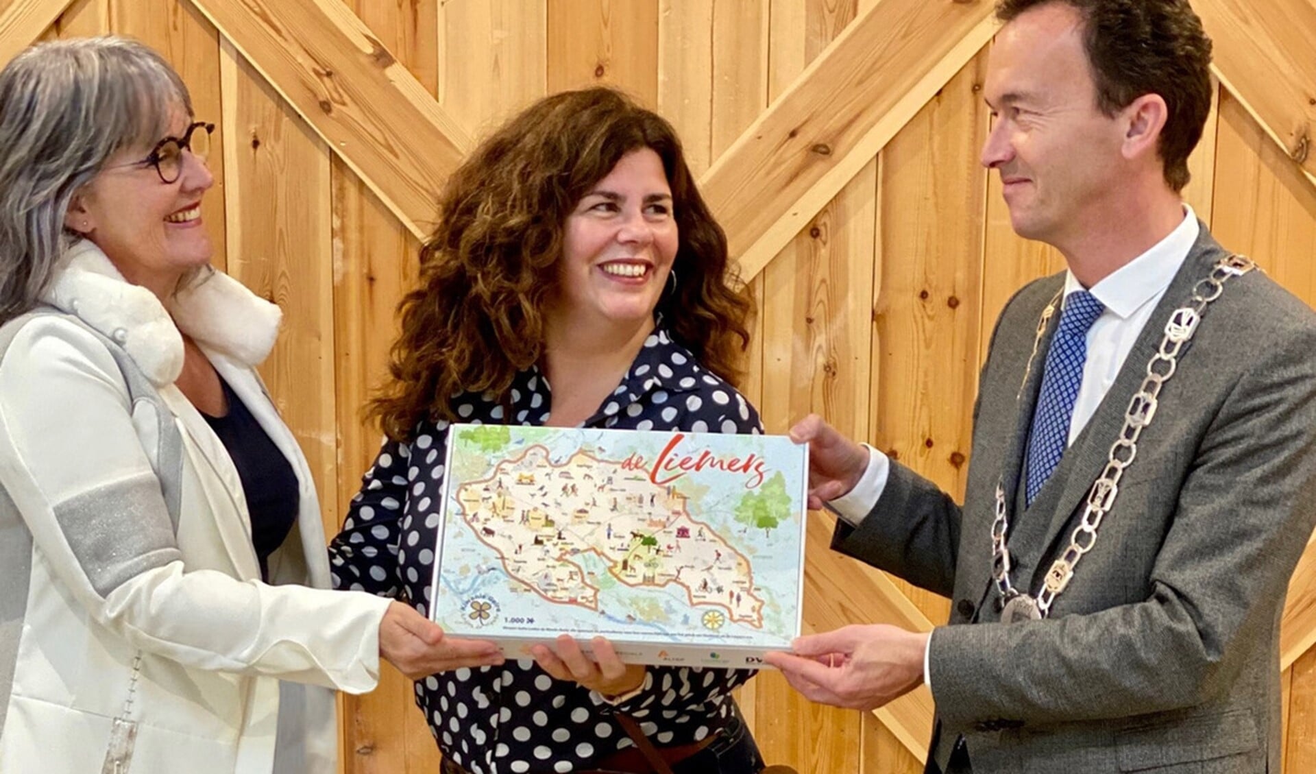 Marjan Span overhandigt de eerste puzzel aan burgemeester Lucien van Riswijk van Zevenaar