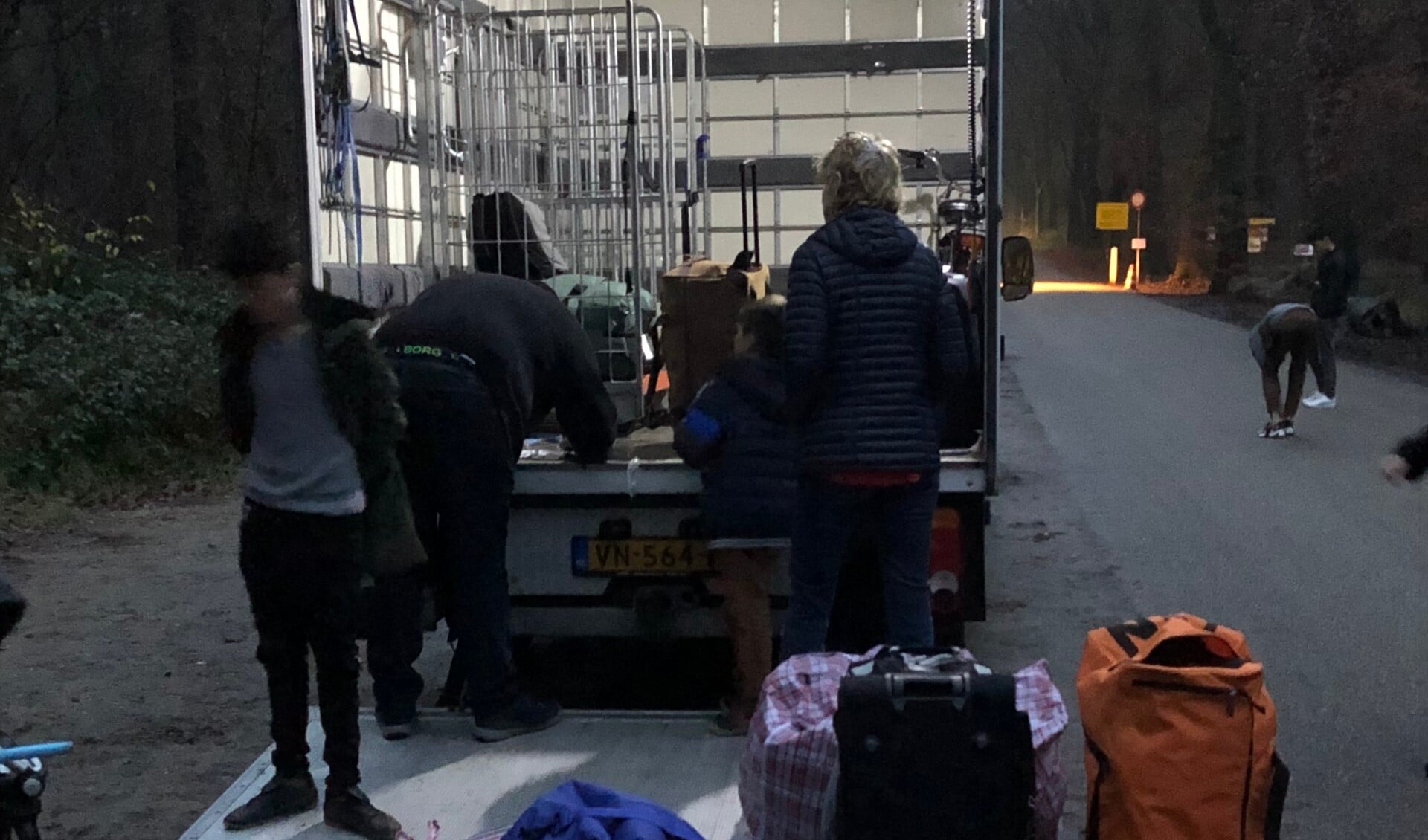 Vrijwilligers met een vrachtwagen zamelen bij Heumensoord bagage van vertrekkende Afghaanse evacués in. 