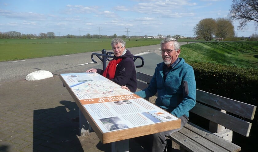 Geert Bouwman en Geert Tijssen (r) van de werkgroep Ommetje Steenoven en Hofstedepad zitten bij het startpaneel van de wandelroute dat tevens dienst doet als tafel. De overige werkgroepleden staan vanwege de coronamaatregelen niet op de foto.