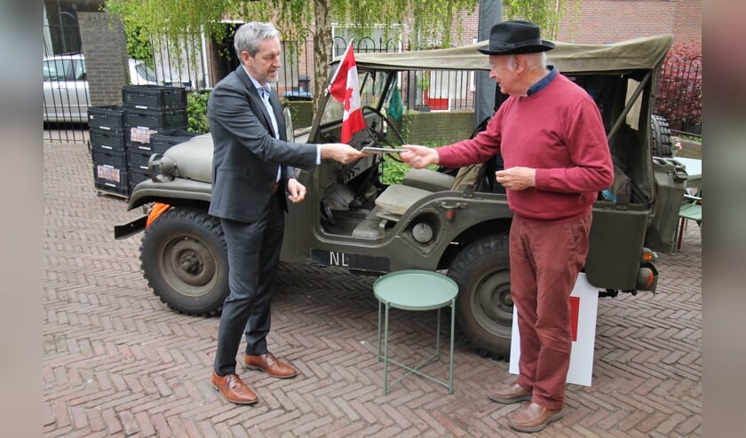 <p>Roeland Janssen (met hoed) overhandigt Rhenens burgemeester Hans van der Pas het fietsrouteboekje. (foto: Marco Diepeveen)</p>