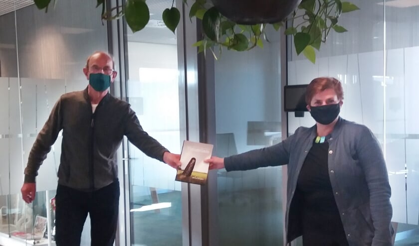 <p>Voorzitter Martien van Hemmen overhandigt het boek Vleugellam aan de ambassadeur Nelly Kalfs.</p>