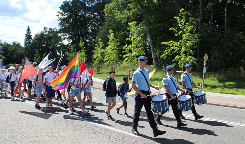 <p>Kinderen lopen in een vlaggenparade met muziek door Groesbeek. (foto: #Vteam)</p>