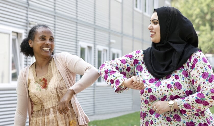 <p>Twee AZC-bewoners groeten elkaar. (foto: Goedele Monnens)</p>