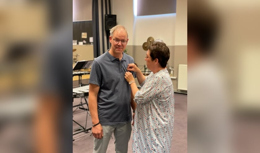 <p>Dirk van Ewijk krijgt versierselen opgespeld door zijn vrouw Gea. (foto: Jeroen van IJmeren)</p>