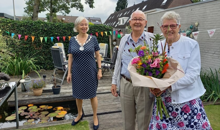 <p>Burgemeester Mittelndorff feliciteert het diamanten paar met een fraai boeket bloemen en een ingelijste trouwacte. (foto: Joop Verstraaten)</p>