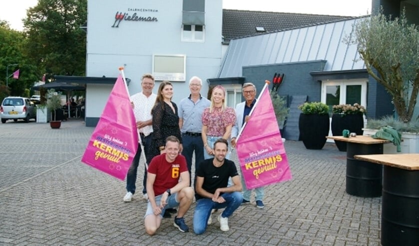 De Westervoortse kermisgangers hebben na de bekendmaking de kermisvlaggen meteen uit de kast gehaald. V.l.n.r.: Ferdinand van Oord, Susan Worm, Martin Wieleman, Debbie Veldink en Kees Krechting. Voor: Arjan Hetterschijt (l) en Tim Koenen.