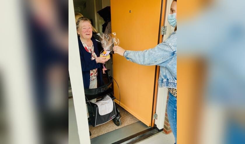 <p>Leerling biedt buurvrouw een attentie aan. (foto: Yvon van Oijen)</p>