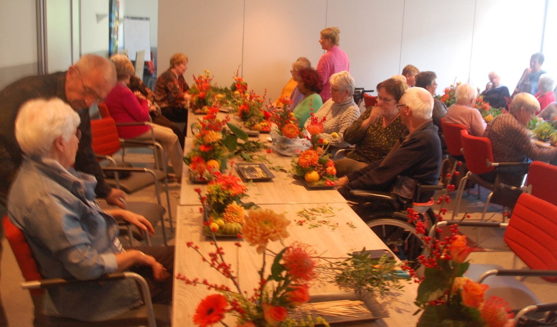Gasten van de Zonnebloem afdeling Zevenaar-West maken herfststukjes onder leiding van Edith Lamers. 